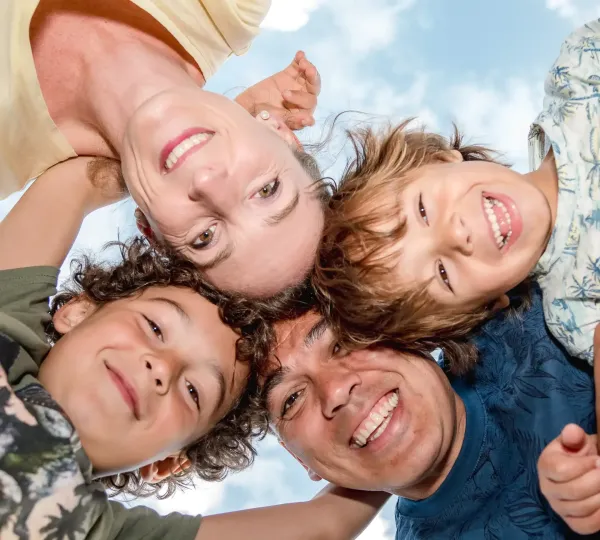Family of four smiling with their heads together