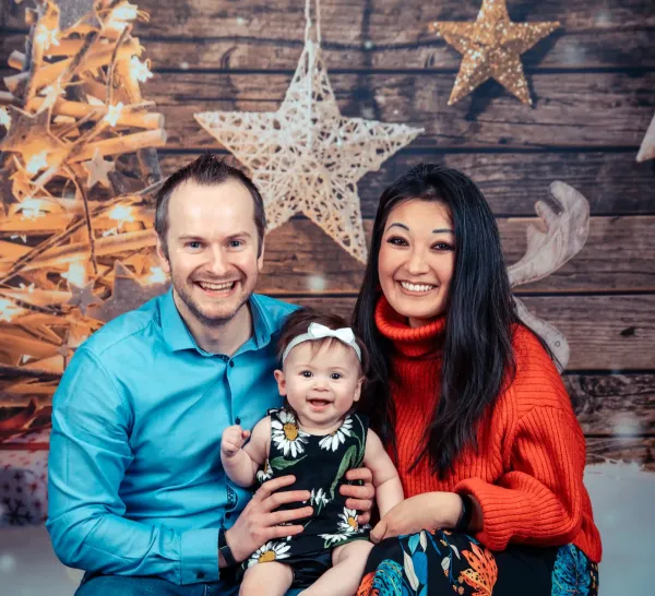 Parents with their baby in a festive Christmas studio setting