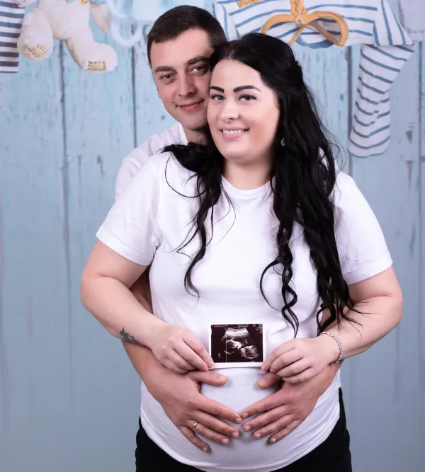 Expectant couple holding an ultrasound photograph